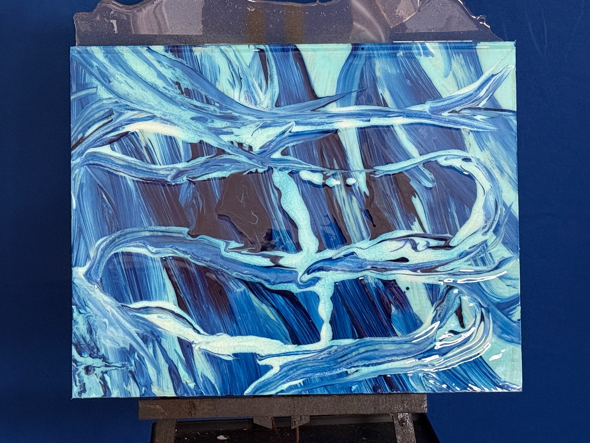 Blue and white abstract artwork on an easel