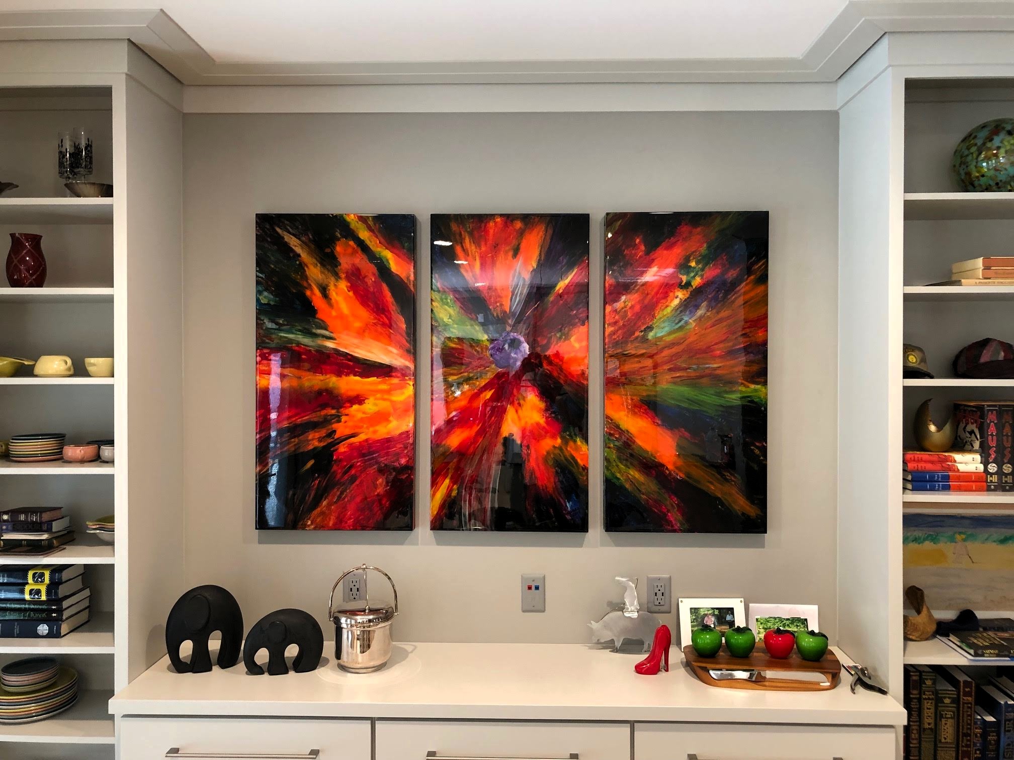 Abstract triptych installed above a built-in cabinet