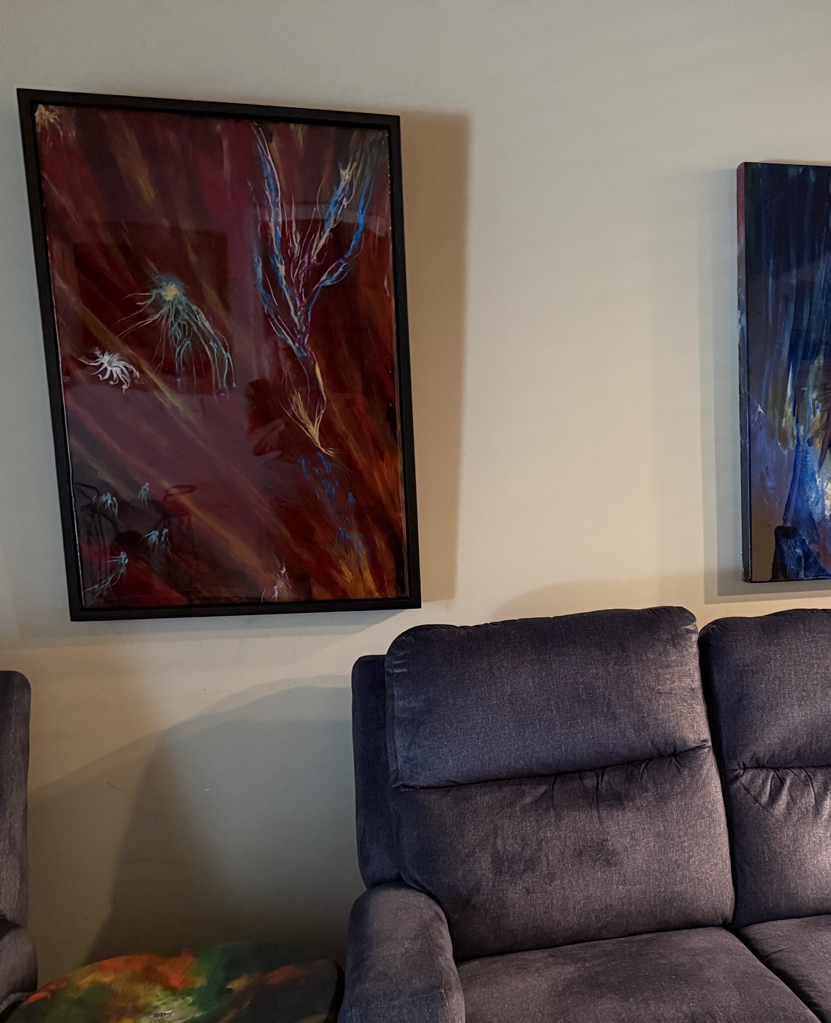 Framed abstract artwork installed above seating