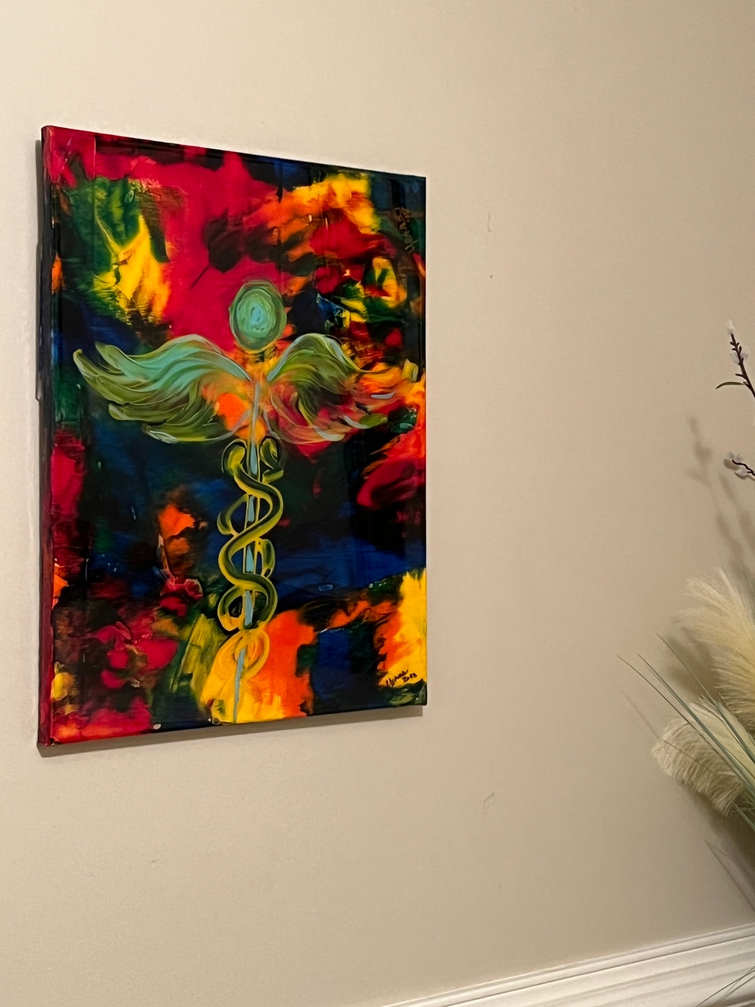 Colorful caduceus-inspired abstract artwork installed on a wall