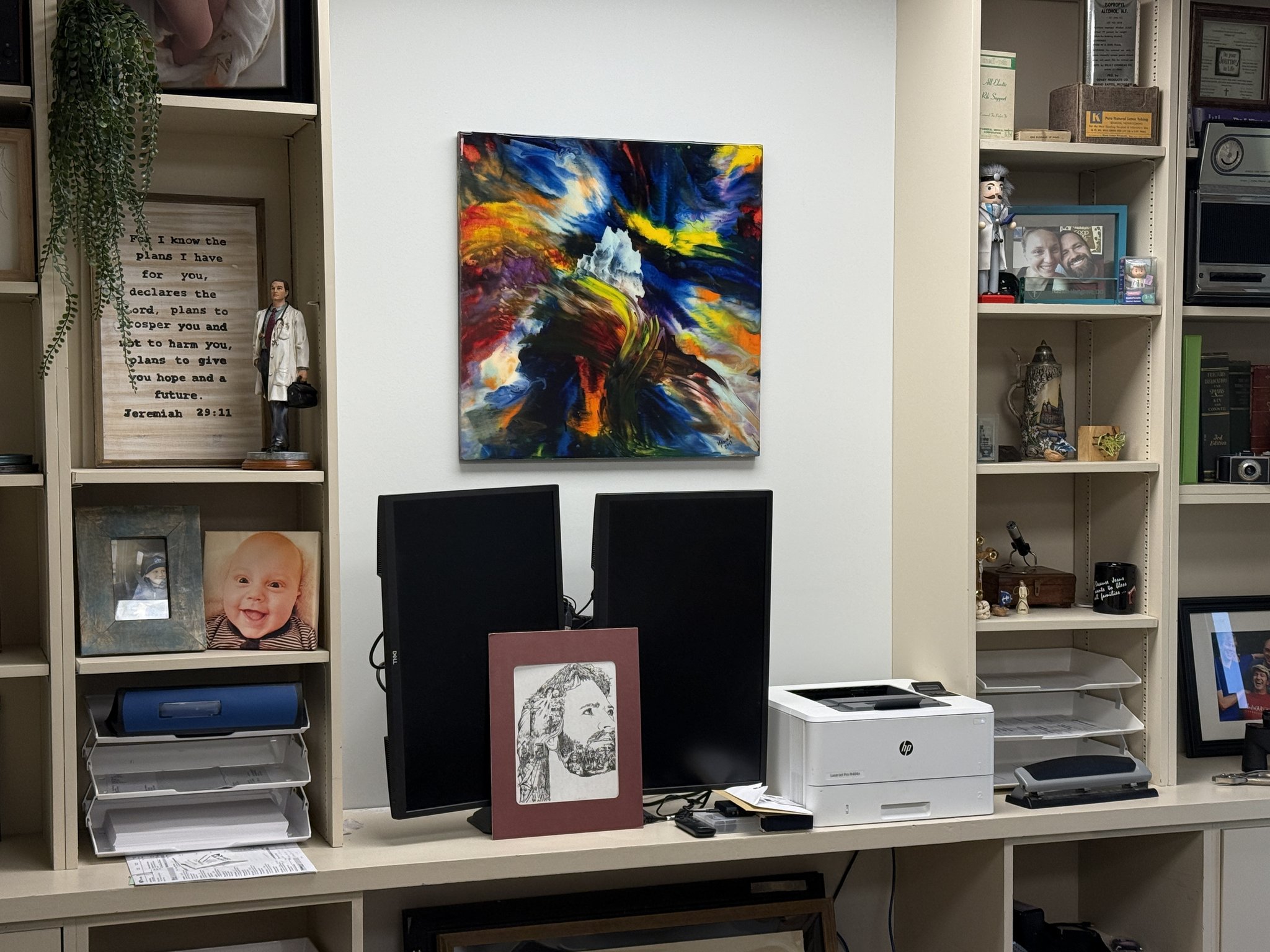 Blue abstract artwork installed above an office workstation