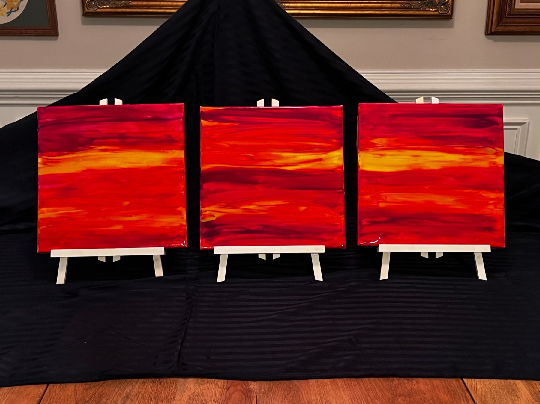 Three small abstract paintings on easels