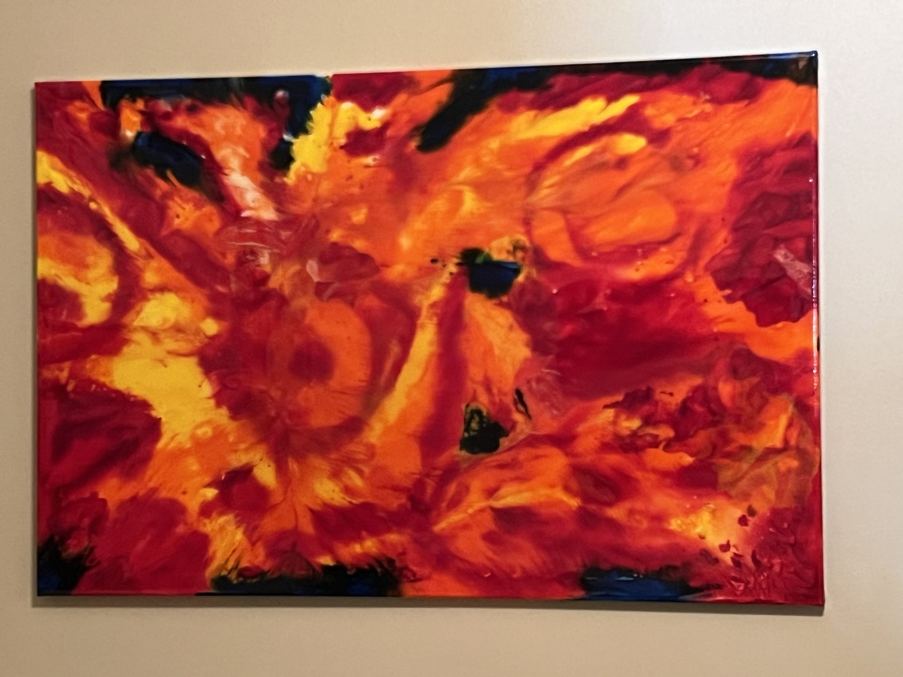 Orange red abstract painting displayed on a wall
